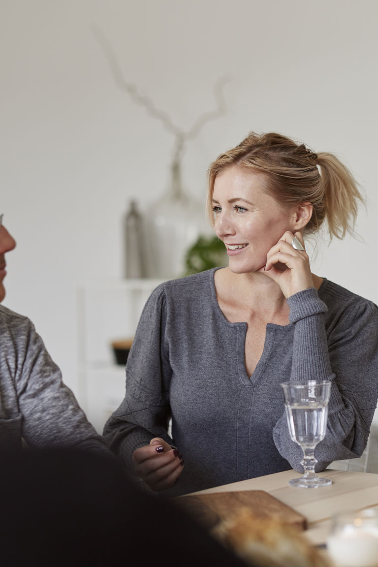 män och kvinnor sitter vid ett bord