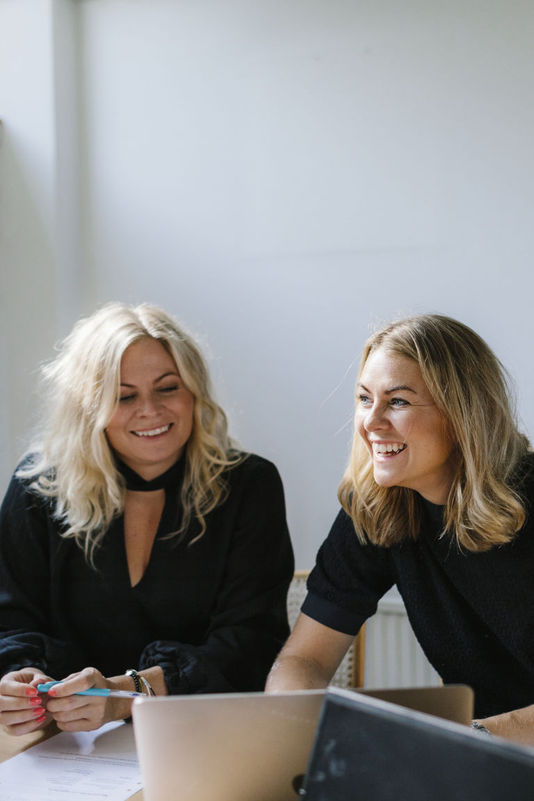 två kvinnor pratar vid ett bord